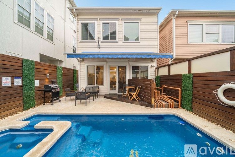 A pool in a backyard with a house in the background.