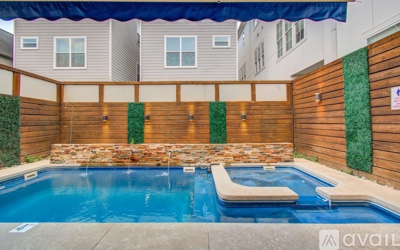 A pool with a stone wall and a wooden fence.