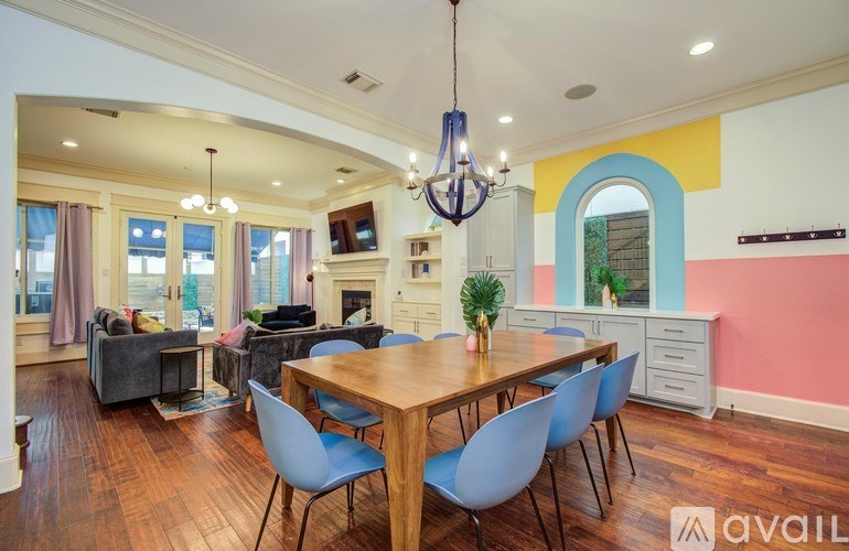 A bedroom with a bed, a couch, a chair, a ceiling fan, and a painting on the wall.