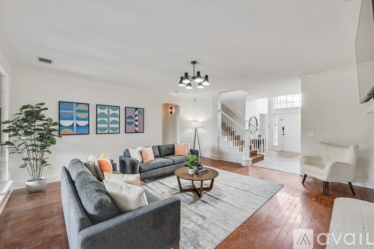 A living room with a grey couch, a coffee table, and a plant.