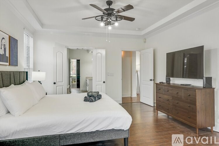 A bedroom with a bed, dresser, and mirror.
