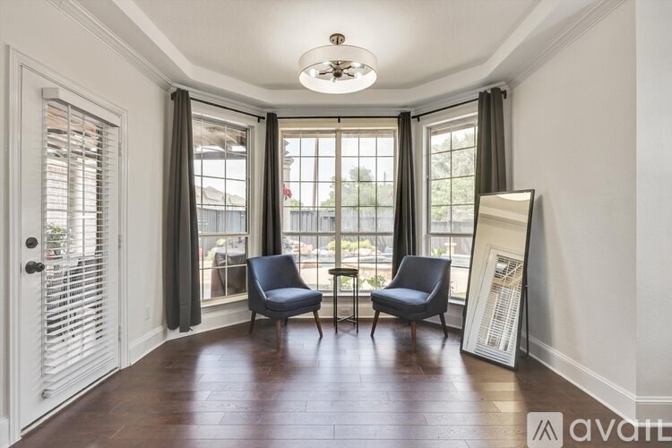 Two chairs are placed in a room with a large window.