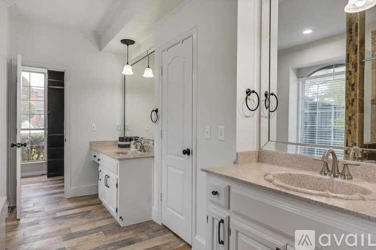 A bathroom with a sink, mirror, and cabinets.