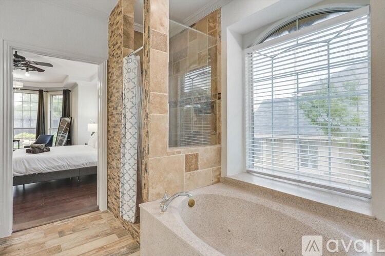 A bathroom with a tub and a window with blinds.