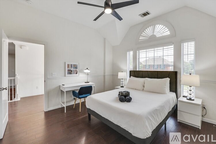 A bedroom with a bed, desk, and chair.