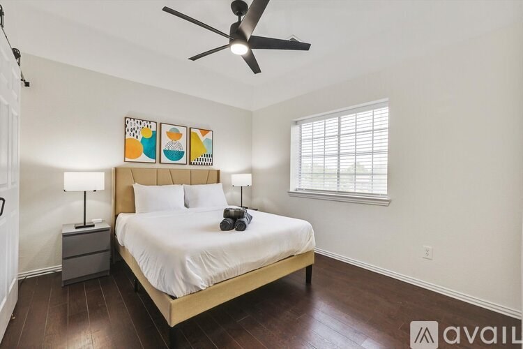 A bedroom with a bed, nightstands, and a ceiling fan.