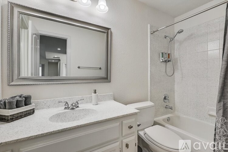 A bathroom with a white sink, toilet, and bathtub.