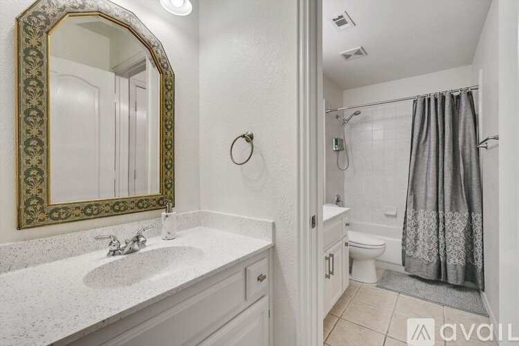 A bathroom with a sink, mirror, and shower.