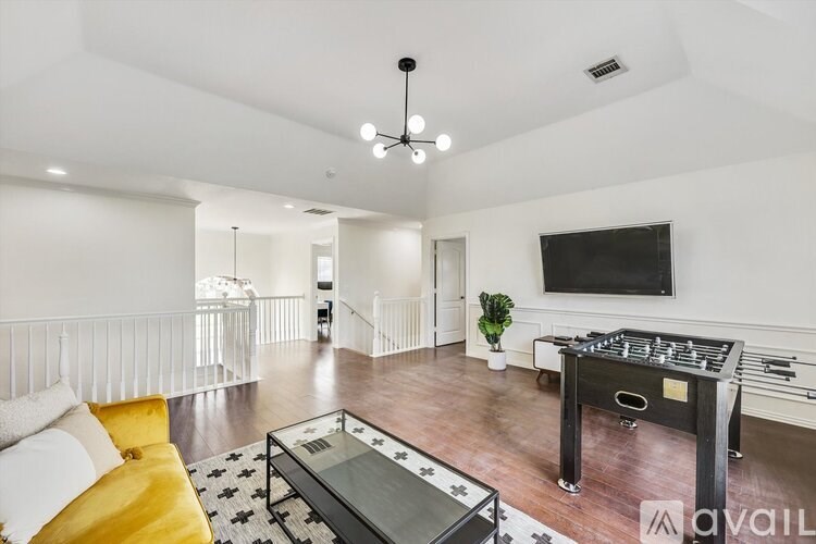 A living room with a pool table and a television.