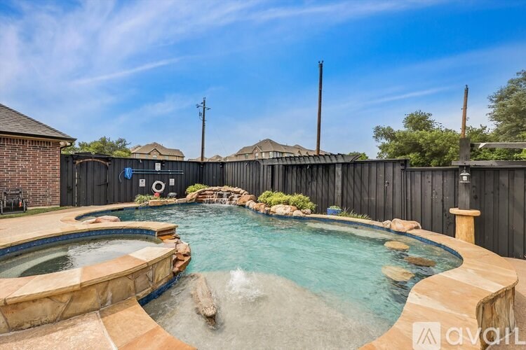 A backyard with a hot tub and a pool.