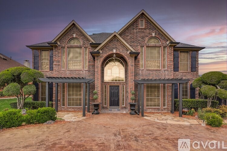 A large, two-story house with a brick facade and a large front yard.