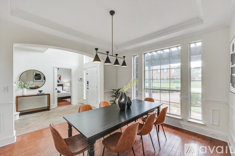 A dining room with a black table and chairs.