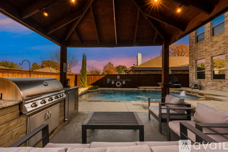 A patio with a grill and a pool.