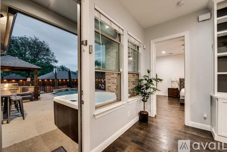 A modern house interior with a hot tub and a view of a backyard.