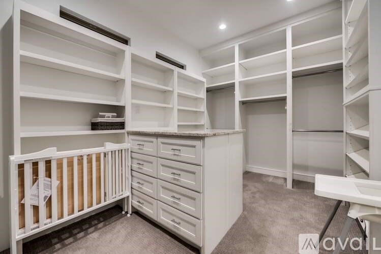 A white walk-in closet with shelves and drawers.