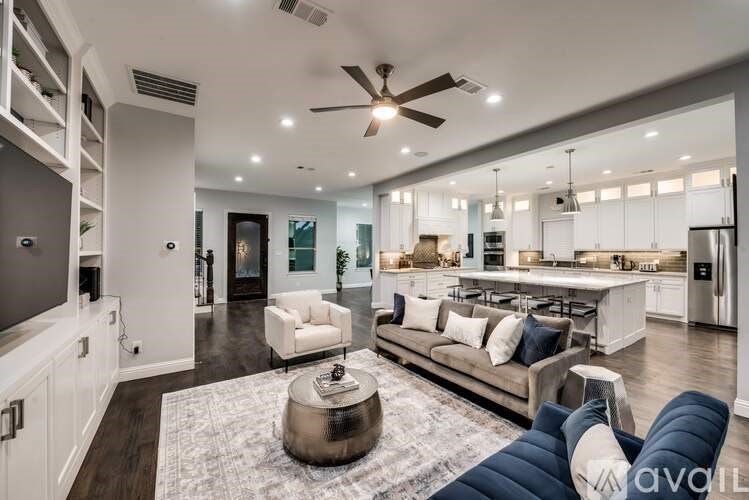 A modern living room with a white sofa and a grey rug.