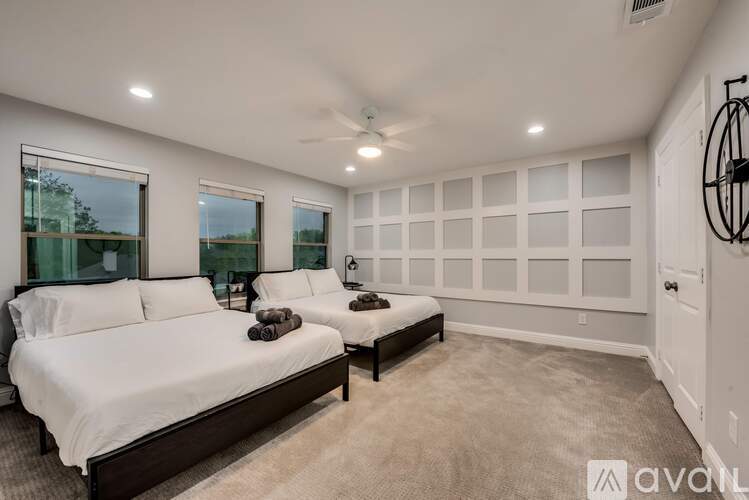 A bedroom with two beds and a ceiling fan.