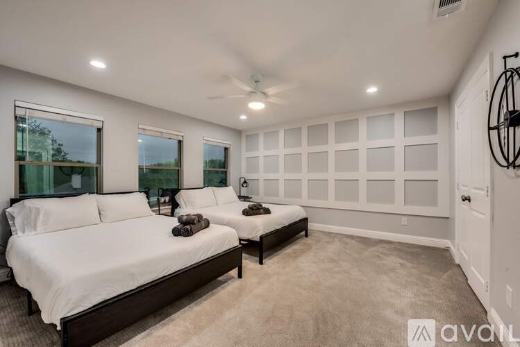 A bedroom with two beds and a ceiling fan.