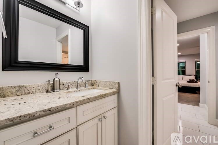 A bathroom with a sink, mirror, and cabinets.