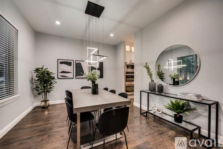 A modern dining room with a large table and chairs.