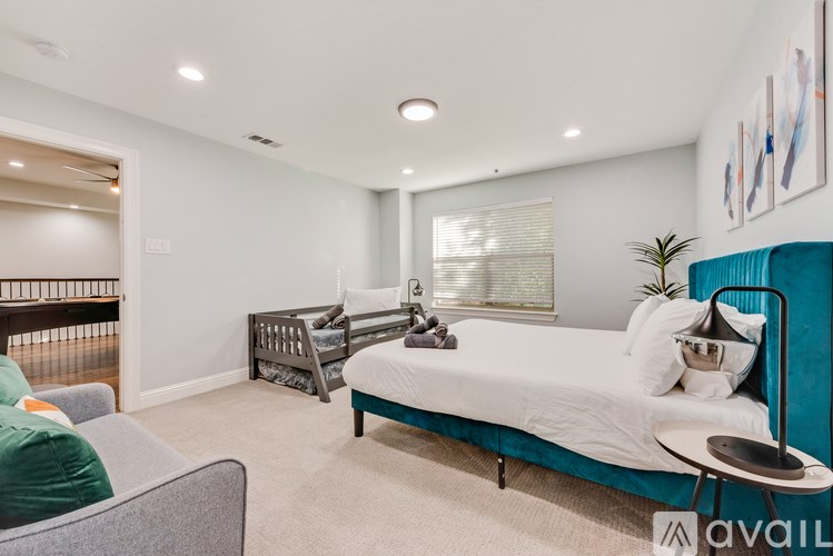 A bedroom with a bed, a chair, and a plant.