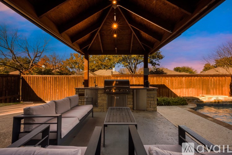A patio with a table and chairs under a roof.