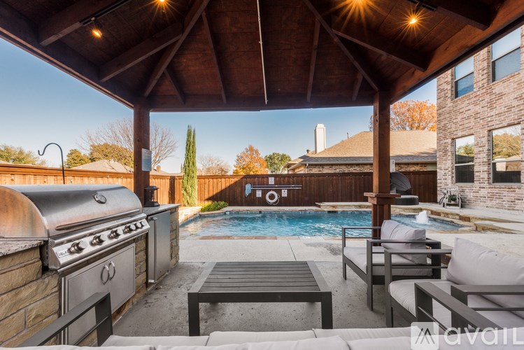 A patio with a grill and a pool.