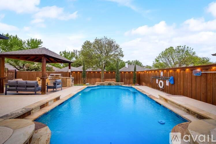 A large outdoor swimming pool with a wooden deck and lounge chairs.