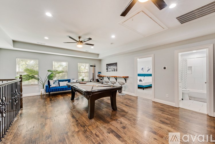 A spacious room with a pool table and a blue sofa.