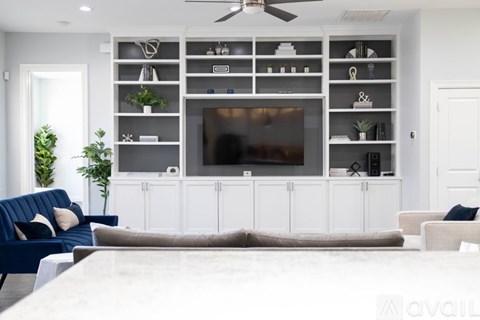 A modern kitchen with a stove top oven and white cabinets.