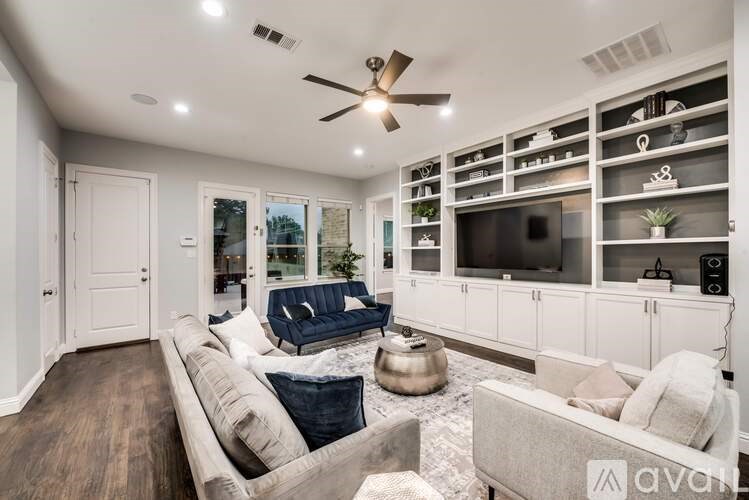 A living room with a couch, a coffee table, and a ceiling fan.