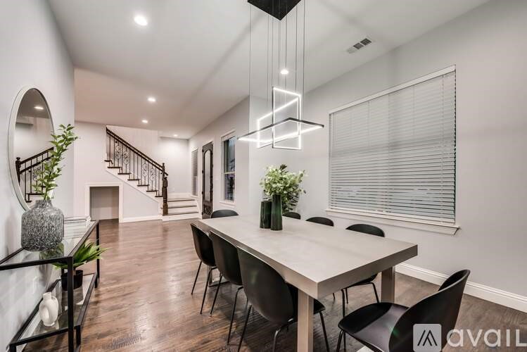 A modern dining room with a long table and chairs.