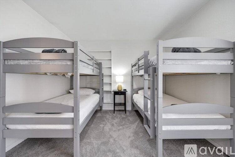 A room with bunk beds and a small table in the middle.