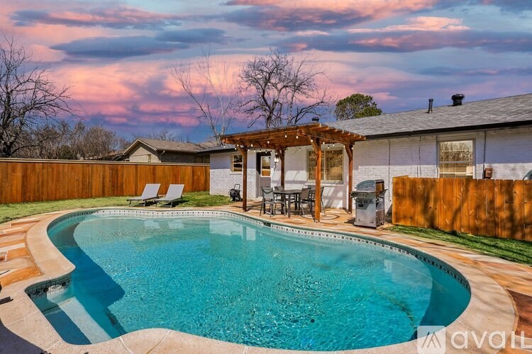 A backyard with a pool and a wooden fence.