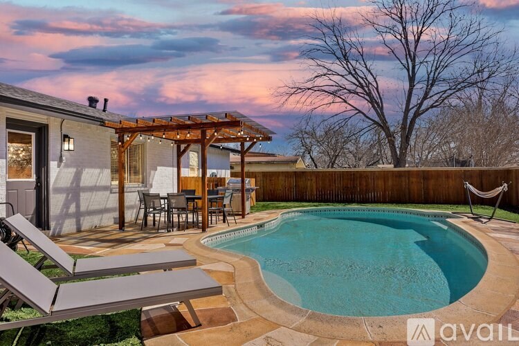 A backyard with a pool and patio furniture.
