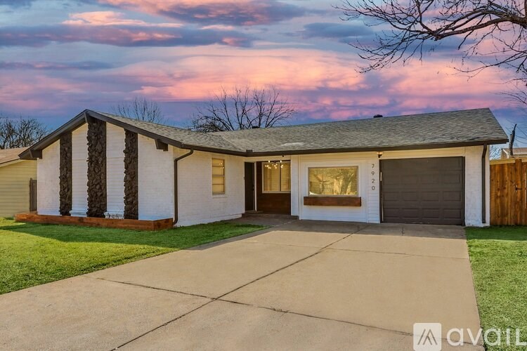A house with a white exterior and a grey roof is shown.