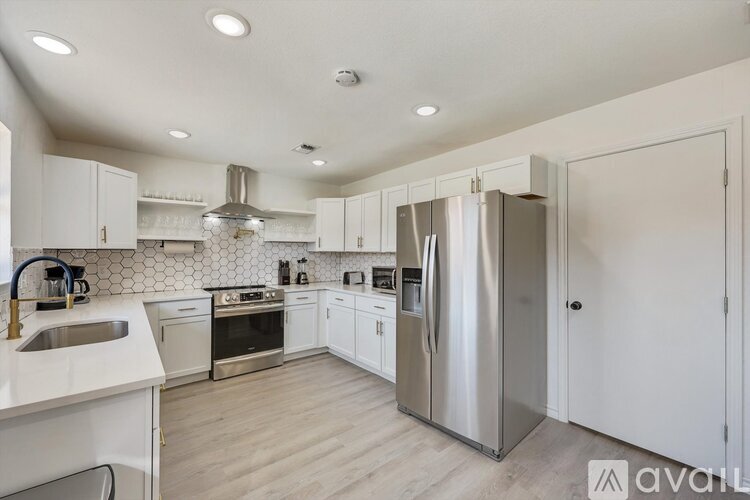 A kitchen with white cabinets and stainless steel appliances.