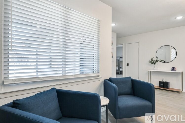 A living room with a blue couch and a matching armchair.