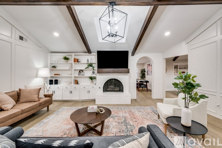 A living room with a brown sofa, a coffee table, and a fireplace.