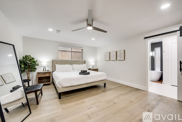 A bedroom with a large bed and a ceiling fan.