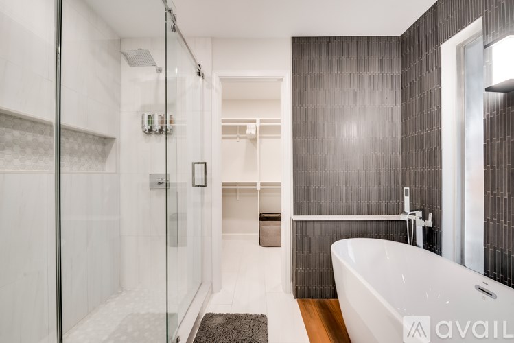 A modern bathroom with a glass shower stall and a white bathtub.