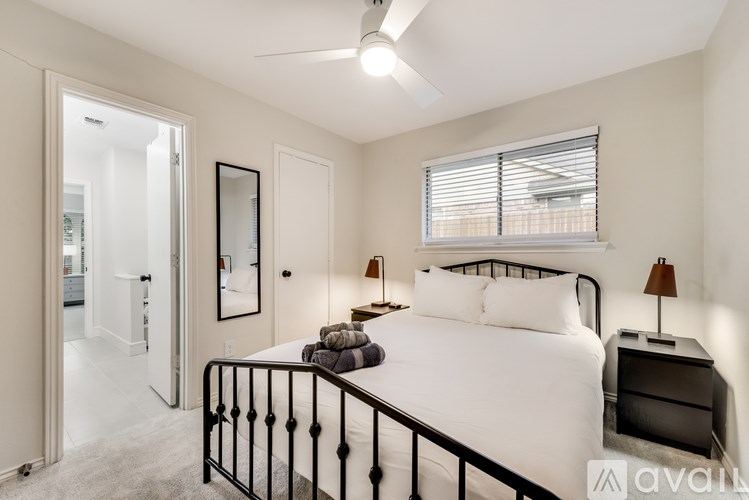 A bedroom with a bed, nightstand, and window.