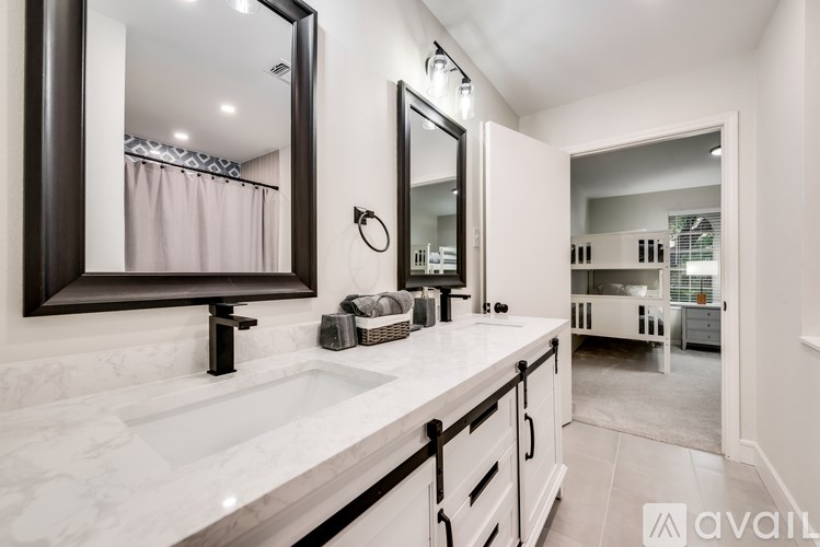 A bathroom with a marble countertop and a large mirror.