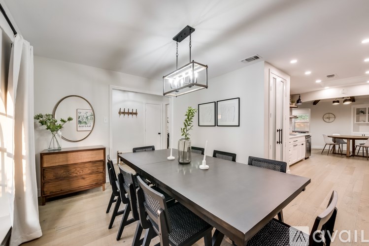A modern dining room with a large table and chairs.