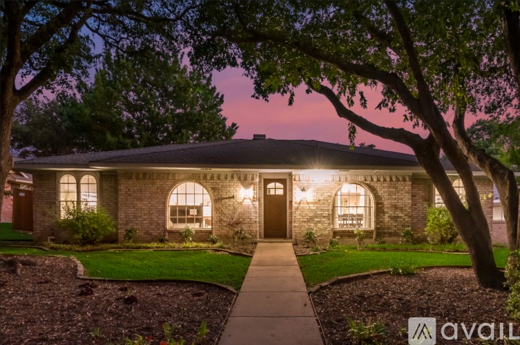 A house with a stone facade and a large tree in front.