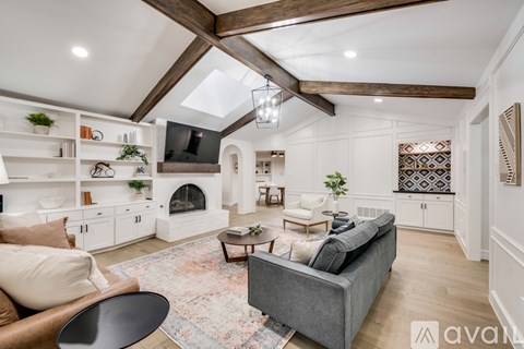 A living room with a grey couch and a fireplace.