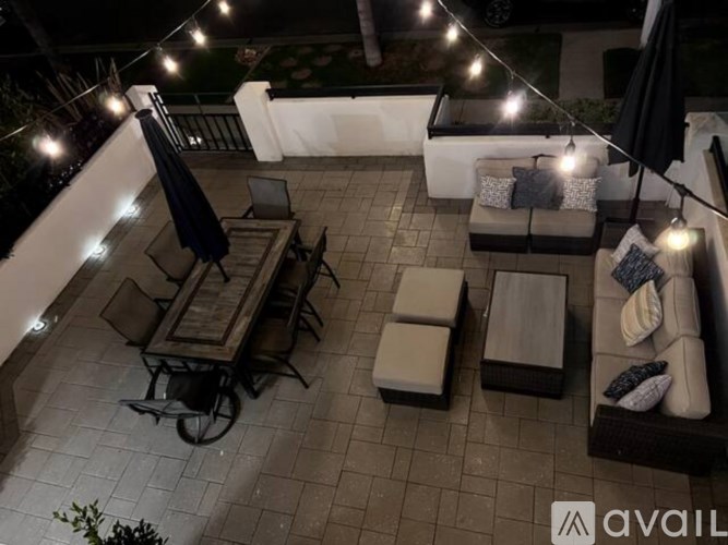 A patio with furniture and string lights.