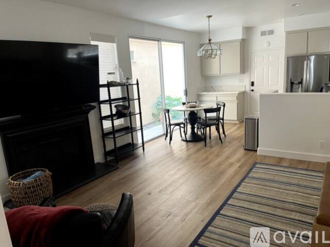 A living room with a fireplace and a dining area.