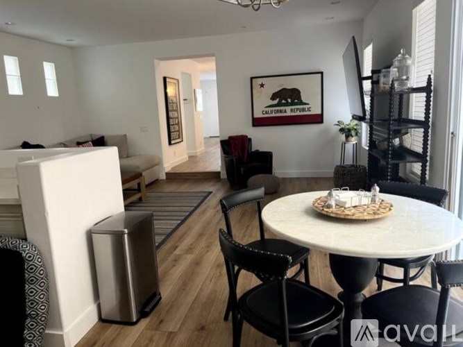 A modern living room with a white couch, a coffee table, and a framed picture of a bear on the wall.