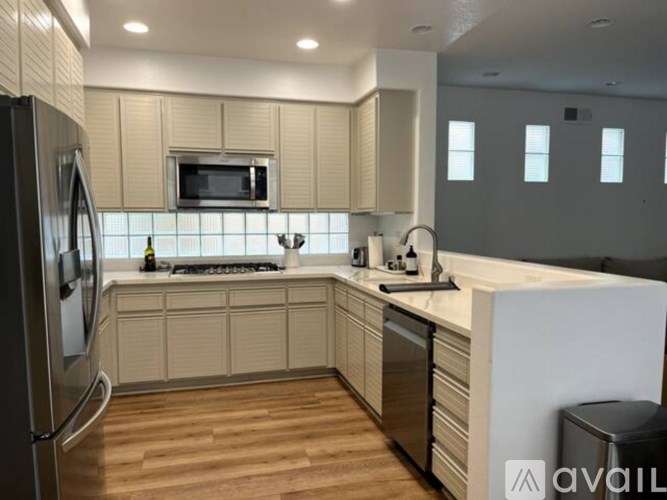 A kitchen with wooden floors and a white countertop.